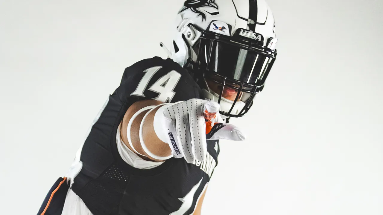 Isaiah Tanner in wide receiver stance wearing full UTSA uniform pointing at you