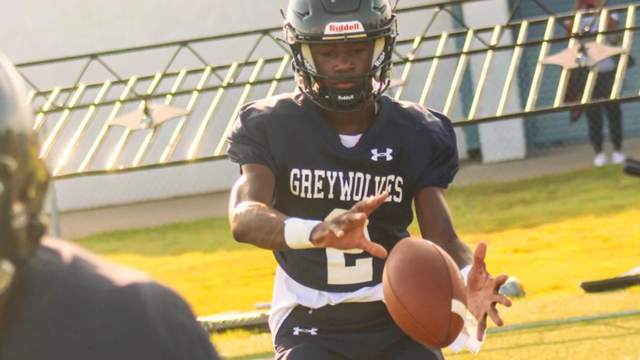 Wide angle shot of Major Curry taking a pre-game snap