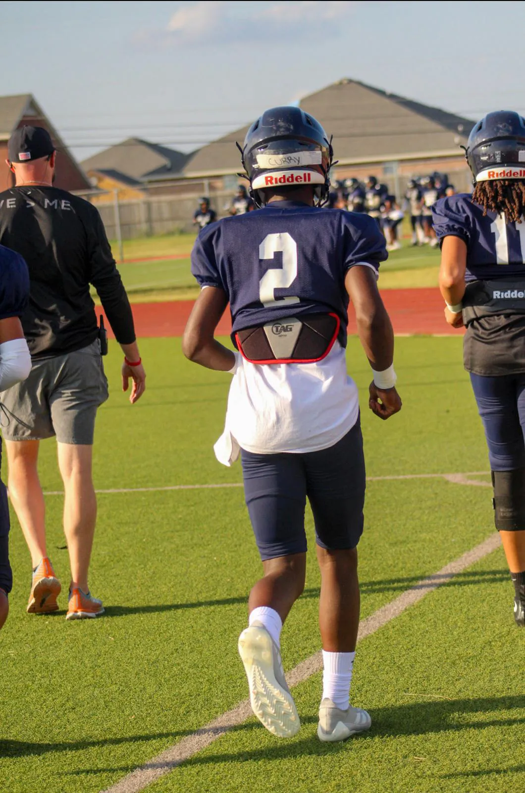 back of Major Curry running on to the field wearing navy blue Shoemaker uniform